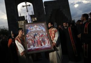 Priests carry an icon to attend a religious service …